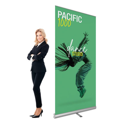 Retractable banner stand with dance studio advertisement displayed at trade shows and events next to businesswoman
