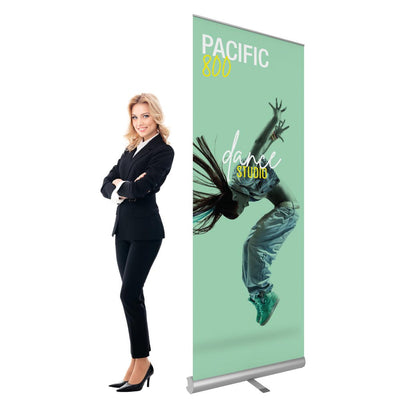 Retractable banner stand with dance studio promotion next to businesswoman, ideal for trade shows and events