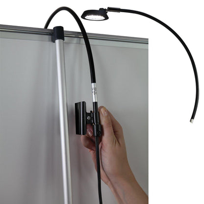 Adjustable clip-on LED light attached to trade show banner stand for exhibitions and events