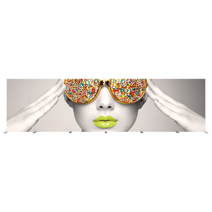 Trade show display featuring close-up of face with decorative oversized sunglasses and vibrant lips artwork