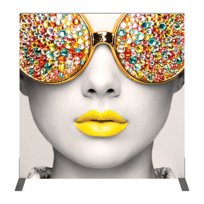 Trade show backdrop featuring close-up of a face with jeweled sunglasses and vibrant lips