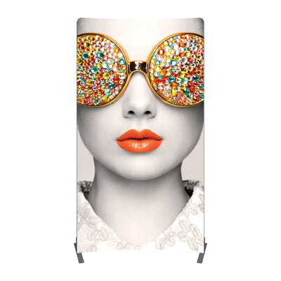 Tall fabric trade show display featuring close-up woman's face with jeweled sunglasses and bright lips