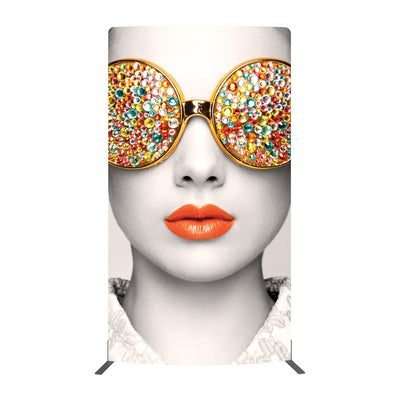 Large graphic display featuring close-up of face with decorative round sunglasses and bold lipstick for trade shows