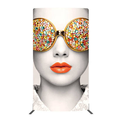 Large graphic display featuring close-up of face with decorative round sunglasses and bold lipstick for trade shows