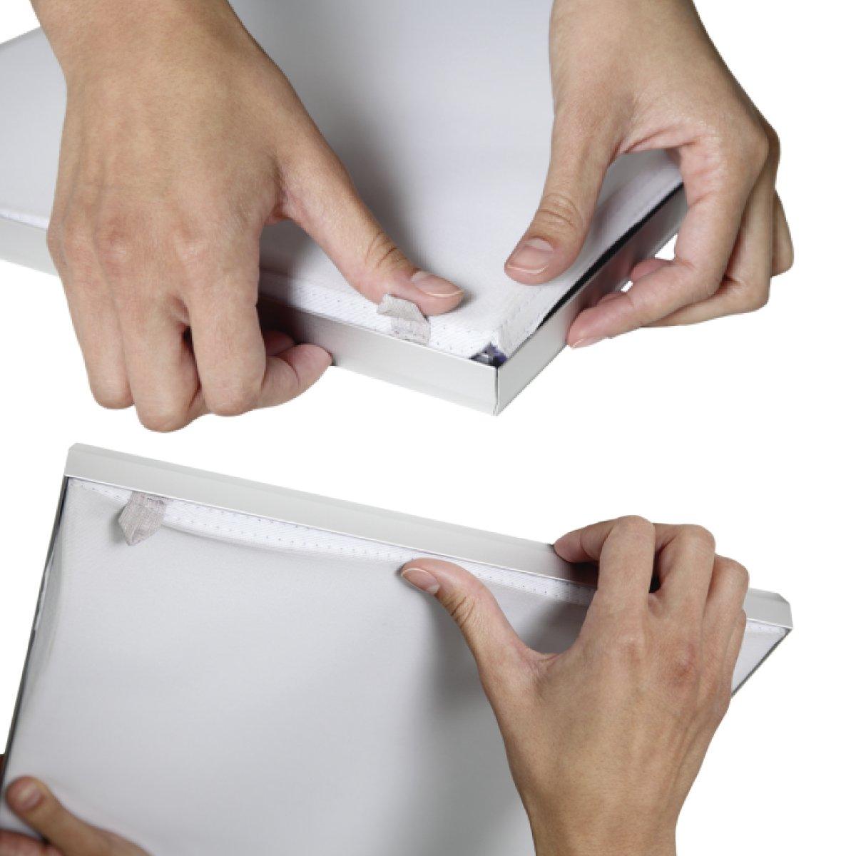 Hands assembling fabric stretch frame edges for trade show or exhibition display setup