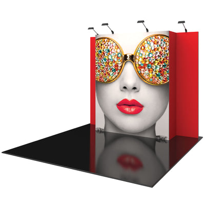 Trade show display booth with large graphic of woman's face wearing embellished sunglasses and spotlight lighting