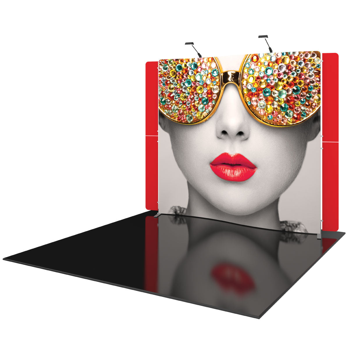 Trade show display featuring a large face graphic with jeweled sunglasses and red lips on a portable backdrop