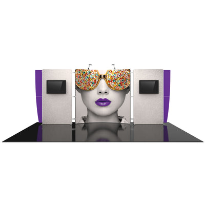 Trade show booth with large graphic panel featuring a woman's face with jeweled sunglasses and purple lips, flanked by display monitors and lighting