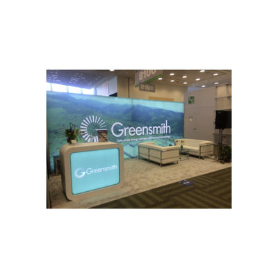 Trade show booth with Greensmith branded lightbox display, seating area, and promotional materials