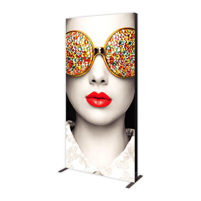 Large vertical trade show lightbox display with artistic close-up of face wearing bejeweled sunglasses and red lipstick