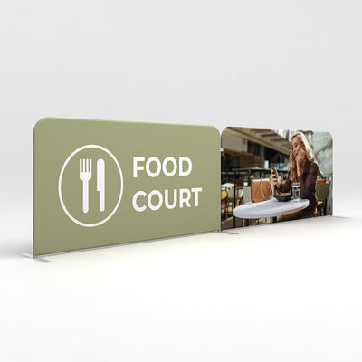Double-sided trade show barrier displaying food court signage and lifestyle image for event promotion
