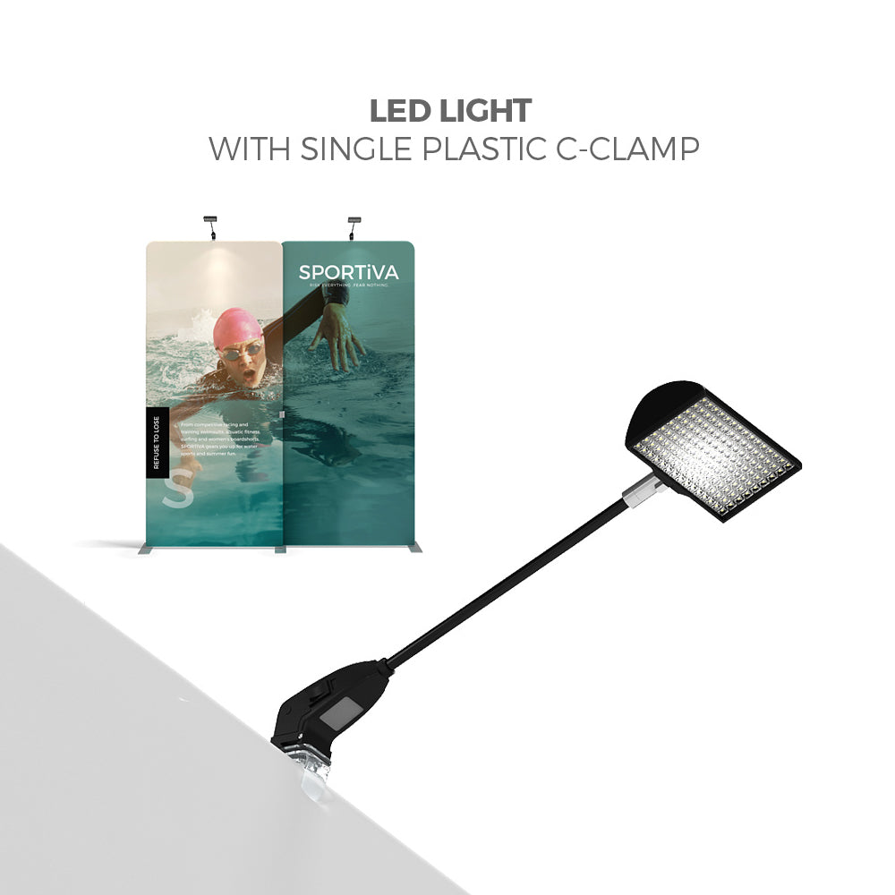 LED light with plastic C-clamp attached to trade show display panels highlighting exhibition graphics