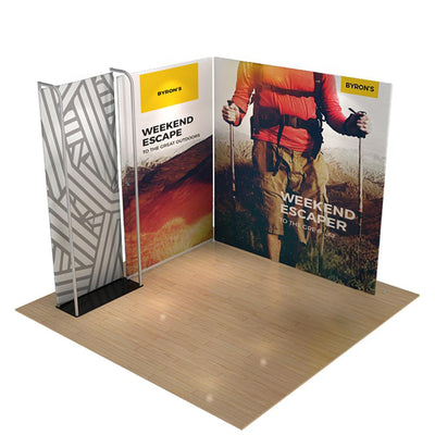 Trade show display featuring large fabric backdrops with outdoor adventure branding on wood floor