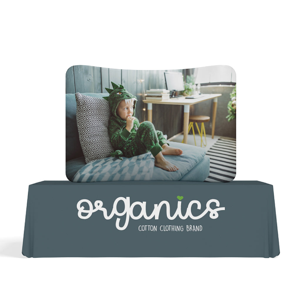 Curved trade show tabletop display with children's clothing brand branding featuring photo of child in costume
