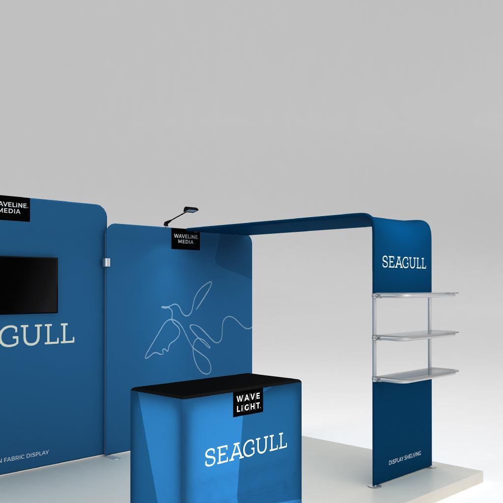 Trade show booth display with curved fabric walls, shelving, table, and overhead structure for exhibitions