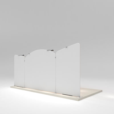 Modular trade show display panels with curved tops and mounted spotlights on exhibition platform