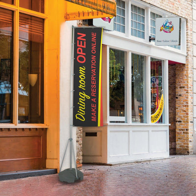 Vertical flag stand displaying promotional banner for dining room reservation in outdoor retail setting