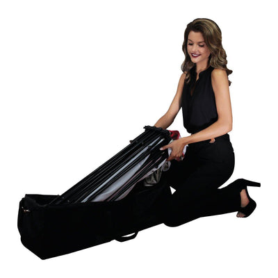 Woman kneeling packing a collapsible trade show display frame into a carrying bag for exhibitions and events