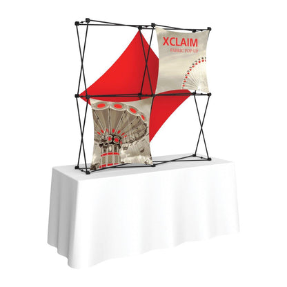 Compact fabric pop-up display on table for trade shows and exhibitions featuring custom printed graphics